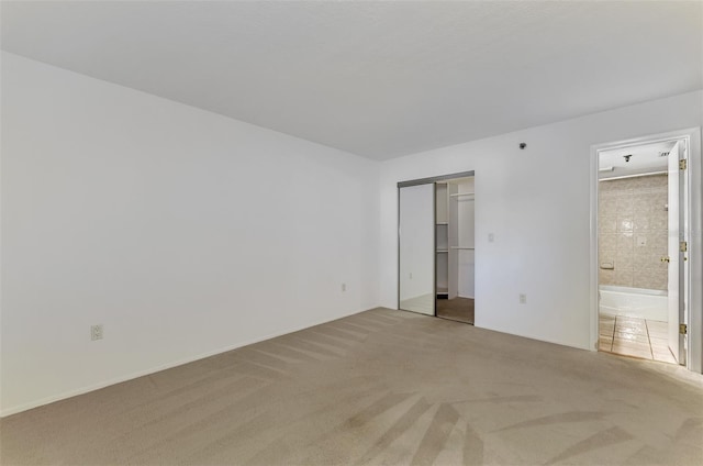 unfurnished bedroom featuring carpet floors, a closet, and connected bathroom