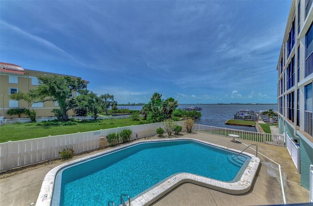 community pool featuring a patio area, a water view, and a fenced backyard