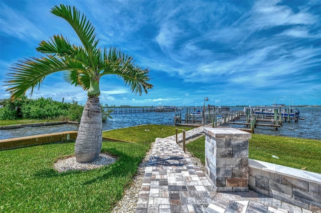 view of dock featuring a yard, a water view, and boat lift