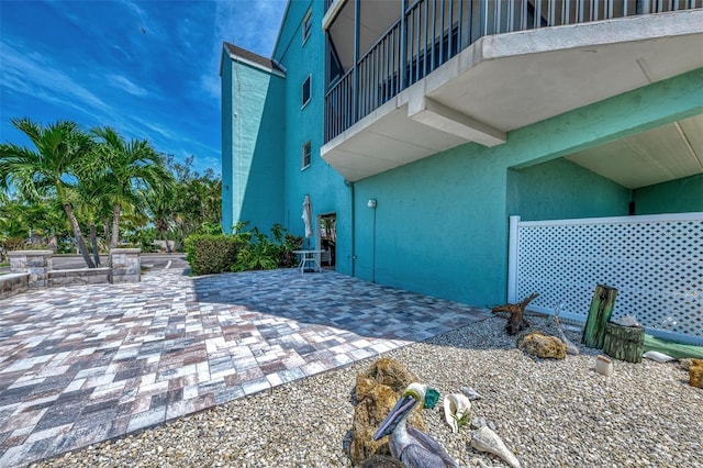 view of home's exterior with a balcony and a patio