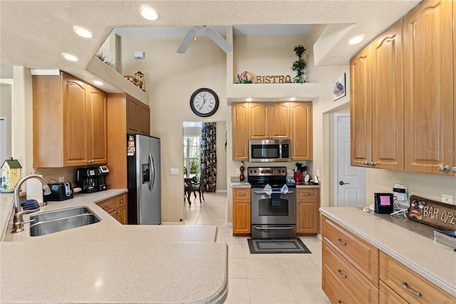 kitchen with ceiling fan, sink, stainless steel appliances, a textured ceiling, and light tile patterned floors