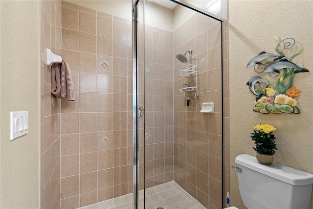 bathroom with a tile shower and toilet