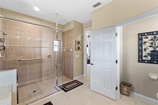 bathroom with toilet, tile patterned floors, and a shower with shower door