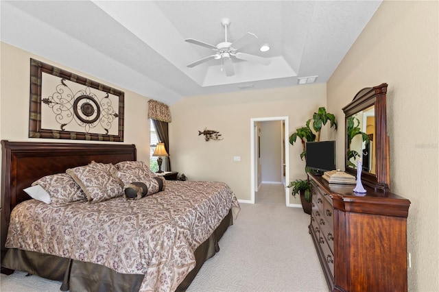 bedroom featuring ceiling fan, light carpet, and a tray ceiling