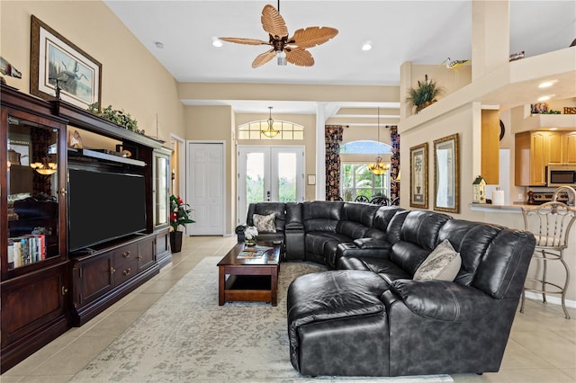 tiled living room with french doors, ceiling fan, and a high ceiling