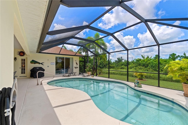 view of swimming pool featuring glass enclosure and a patio