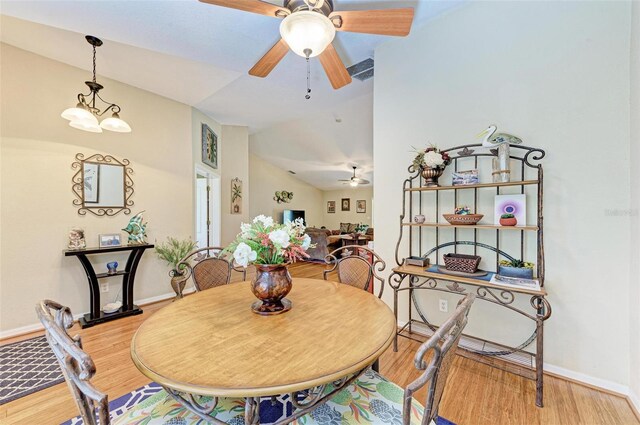 dining area with ceiling fan, light hardwood / wood-style flooring, and lofted ceiling