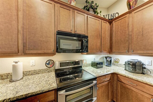 kitchen with light stone countertops and stainless steel electric range oven