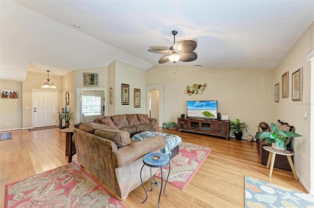 living room with ceiling fan, light wood-type flooring, and lofted ceiling