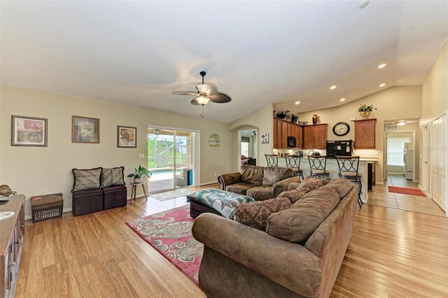 living room with ceiling fan, light hardwood / wood-style flooring, and lofted ceiling