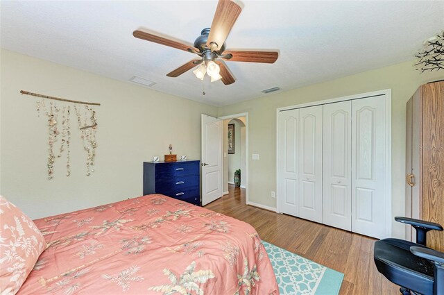 bedroom featuring ceiling fan, light hardwood / wood-style floors, and a closet