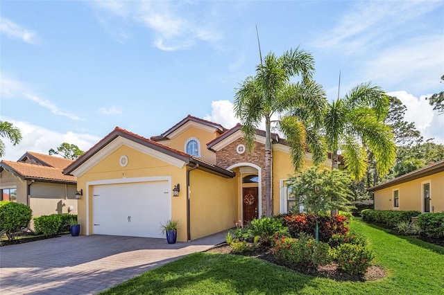 mediterranean / spanish house with a garage and a front lawn