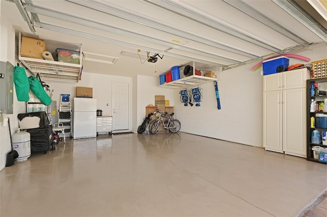 garage with a garage door opener and freestanding refrigerator