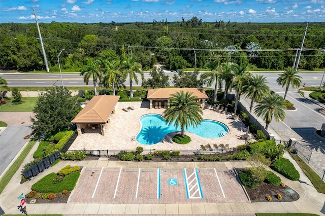 community pool with a patio area and fence