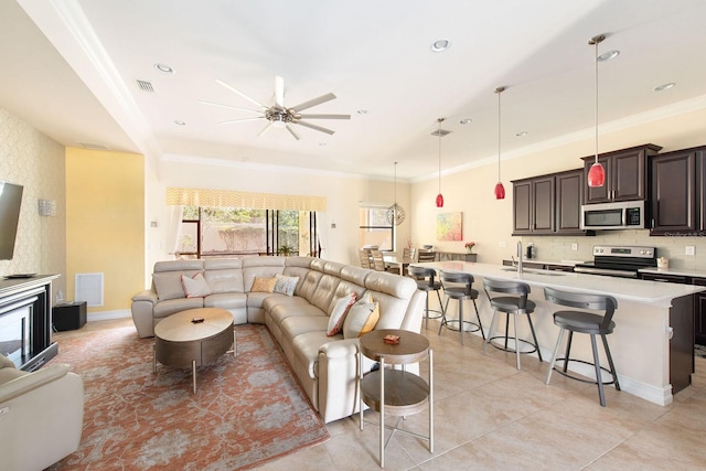 living area with ornamental molding, recessed lighting, visible vents, and ceiling fan