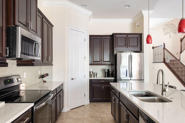 kitchen featuring decorative light fixtures, crown molding, appliances with stainless steel finishes, light tile patterned flooring, and a sink