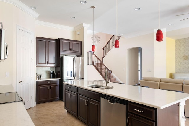 kitchen with an island with sink, decorative light fixtures, stainless steel appliances, dark brown cabinets, and light countertops