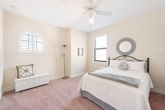 bedroom with light carpet, ceiling fan, and baseboards