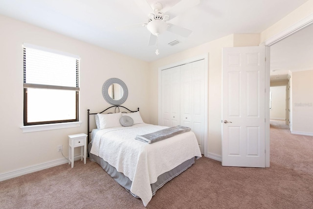 carpeted bedroom featuring ceiling fan, a closet, visible vents, and baseboards