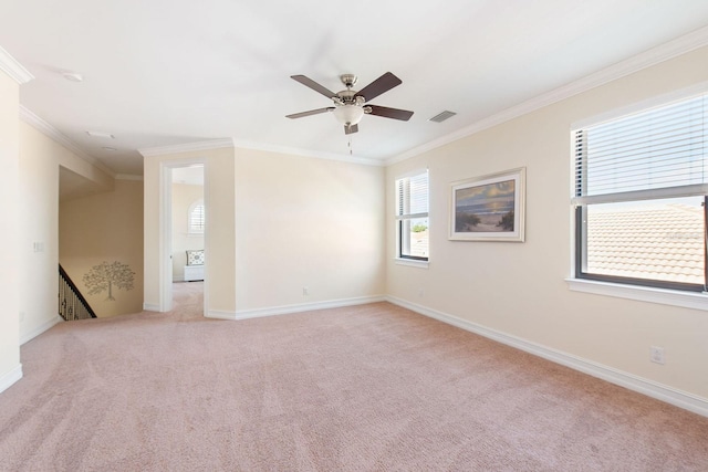 spare room with light colored carpet, visible vents, crown molding, and baseboards