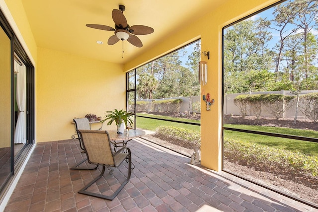 sunroom / solarium with a ceiling fan