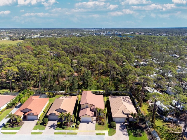 drone / aerial view featuring a residential view and a wooded view