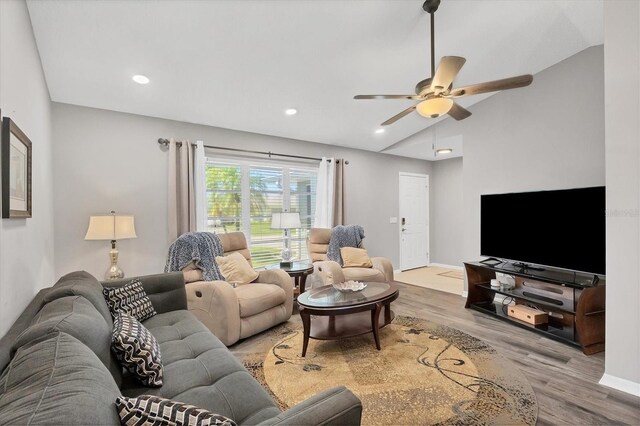 living room with ceiling fan, lofted ceiling, and light hardwood / wood-style floors