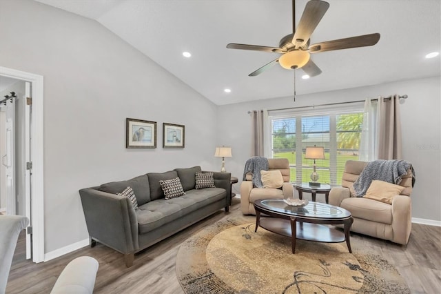 living area featuring lofted ceiling, baseboards, and wood finished floors