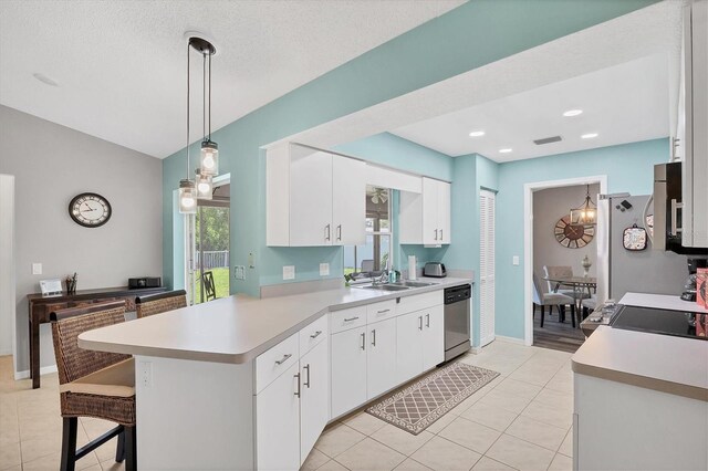 kitchen featuring white cabinetry, kitchen peninsula, hanging light fixtures, dishwasher, and a kitchen breakfast bar