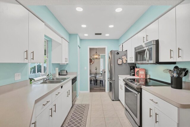 kitchen featuring light wood-type flooring, stainless steel appliances, sink, and white cabinetry