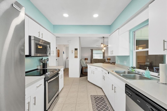 kitchen featuring stainless steel appliances, white cabinets, ceiling fan, sink, and light tile patterned flooring