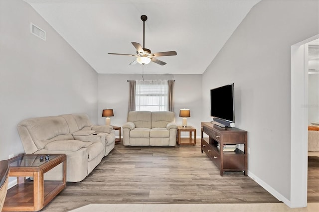 living room with light wood finished floors, lofted ceiling, visible vents, a ceiling fan, and baseboards