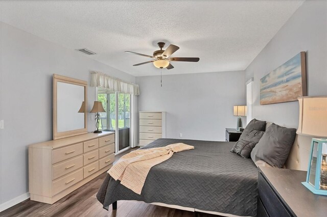 bedroom featuring ceiling fan, a textured ceiling, and dark hardwood / wood-style floors