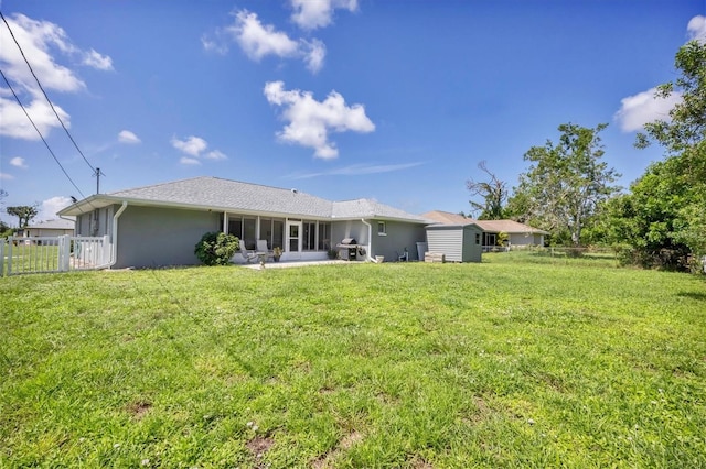 rear view of property with a lawn, a patio area, fence, and stucco siding