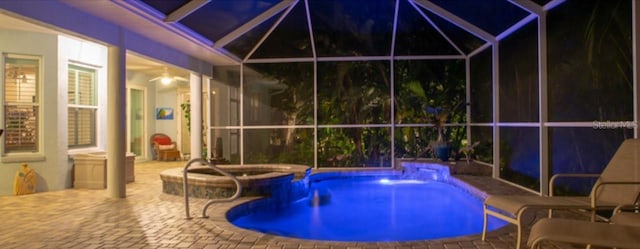 view of swimming pool featuring an in ground hot tub, a patio, and a lanai