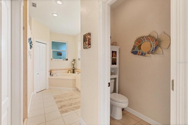 bathroom with tile patterned flooring, toilet, and a tub