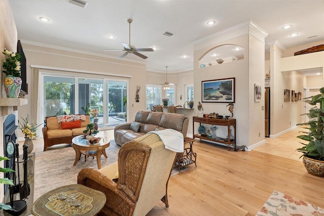 living room with light hardwood / wood-style floors, ceiling fan, and ornamental molding