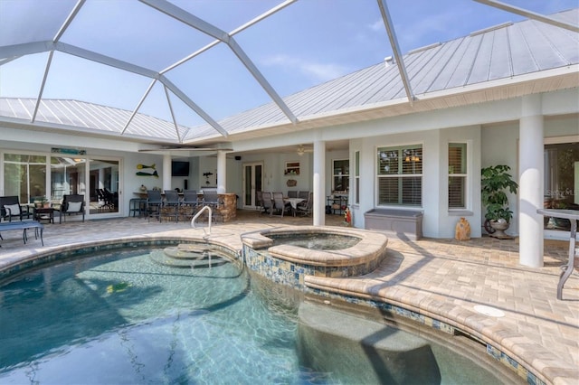 view of swimming pool with a patio, ceiling fan, an in ground hot tub, and glass enclosure