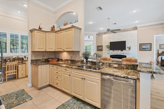 kitchen with sink, dishwasher, kitchen peninsula, and dark stone countertops