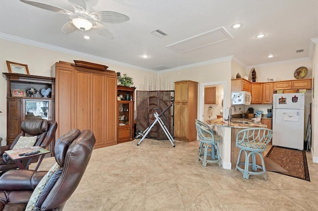 interior space with white appliances, light stone counters, a kitchen breakfast bar, ceiling fan, and ornamental molding