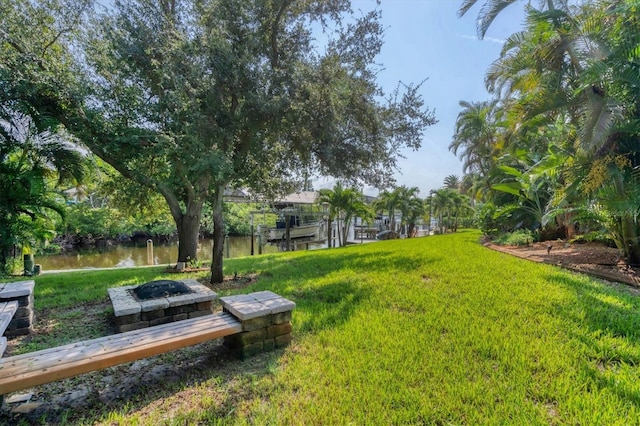 view of yard with a water view and a fire pit