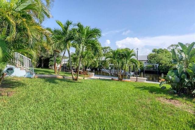 view of yard featuring a water view and a boat dock