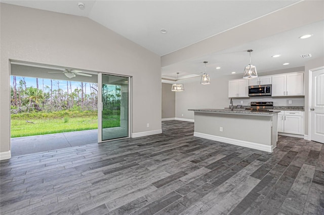 kitchen featuring white cabinets, dark wood-type flooring, decorative light fixtures, an island with sink, and stainless steel appliances