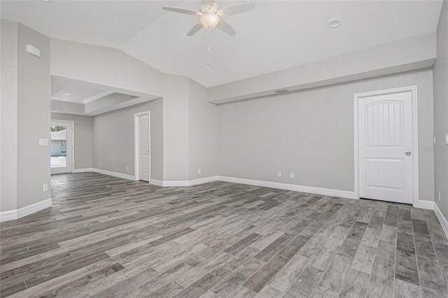 unfurnished room featuring ceiling fan, hardwood / wood-style flooring, a raised ceiling, and lofted ceiling