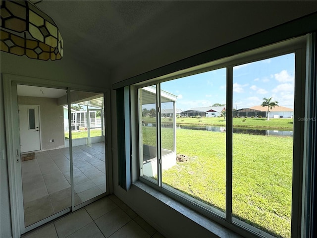 entryway with a water view, a residential view, vaulted ceiling, and tile patterned floors