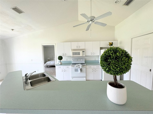 kitchen featuring white appliances, white cabinets, a sink, and visible vents