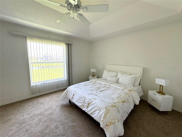 carpeted bedroom featuring ceiling fan, a textured ceiling, and a tray ceiling