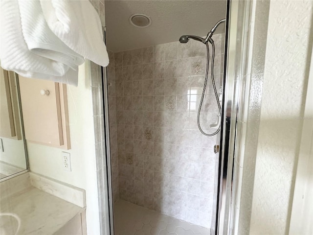 bathroom with a shower stall and vanity