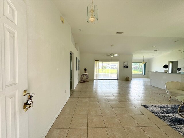 hall featuring lofted ceiling and light tile patterned floors