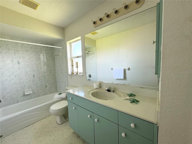 full bathroom with toilet, tiled shower / bath, vanity, and tile patterned floors